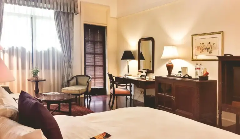 Hotel Majapahit Surabaya MGallery – Surabaya, Indonesia hotel – a hotel room with a bed and a desk at Hotel Majapahit Surabaya MGallery in Surabaya